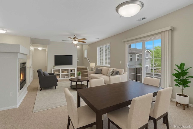5255 Memphis St Unit 1009, Denver, CO 80239 - dining room featuring light carpet, a tiled fireplace, and ceiling fan