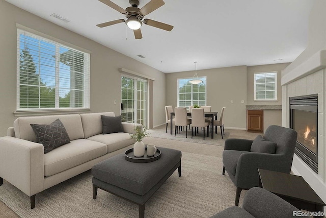 5255 Memphis St Unit 1009, Denver, CO 80239 - living room featuring light colored carpet, a tile fireplace, and a ceiling fan