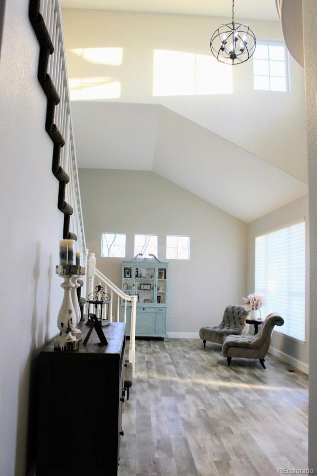 interior space with a healthy amount of sunlight, high vaulted ceiling, and an inviting chandelier