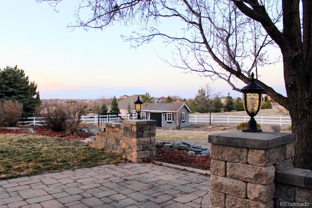 patio terrace at dusk featuring fence