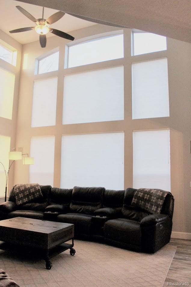 living room featuring a ceiling fan and a towering ceiling