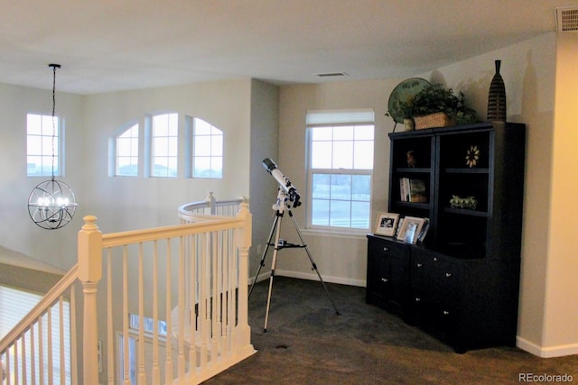 interior space featuring dark colored carpet, visible vents, and plenty of natural light