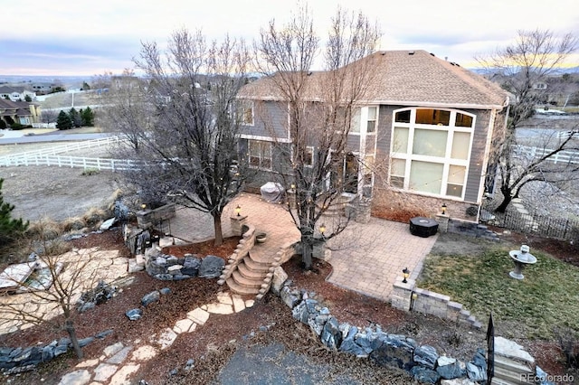 view of front facade with a patio area and fence