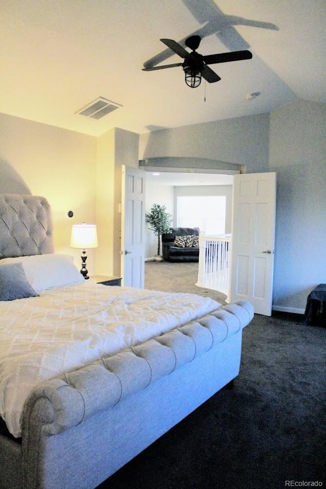 bedroom with visible vents, lofted ceiling, a ceiling fan, and carpet flooring