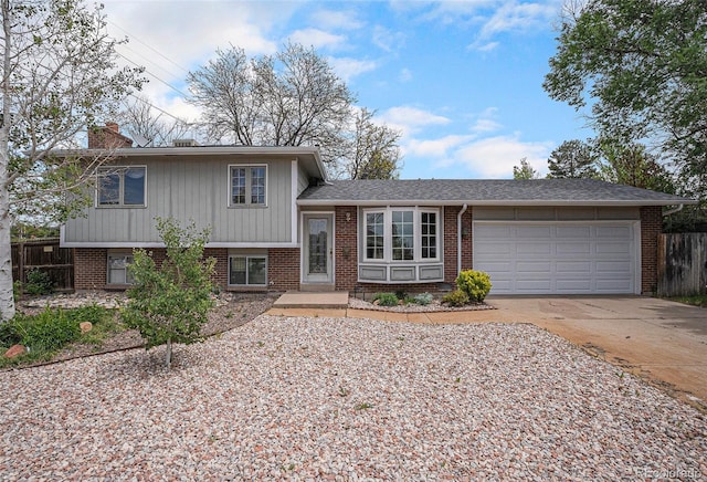 1947 S Ouray St, Aurora, CO 80013 - split level home with an attached garage, driveway, brick siding, and fence