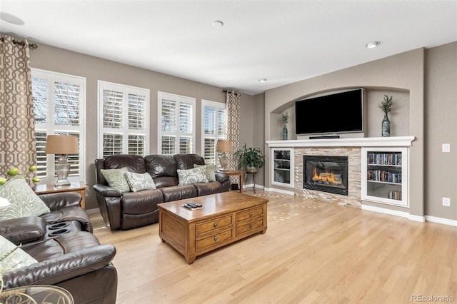 6690 S Fenton St, Littleton, CO 80123 - living room with baseboards, a glass covered fireplace, and light wood-style floors