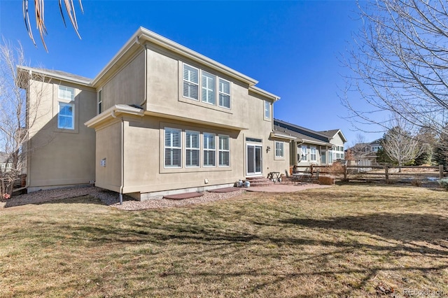 6690 S Fenton St, Littleton, CO 80123 - back of property with entry steps, stucco siding, a yard, and a patio area