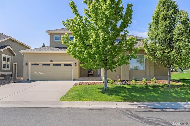 6690 S Fenton St, Littleton, CO 80123 - view of property hidden behind natural elements featuring concrete driveway, stucco siding, a front lawn, and central AC