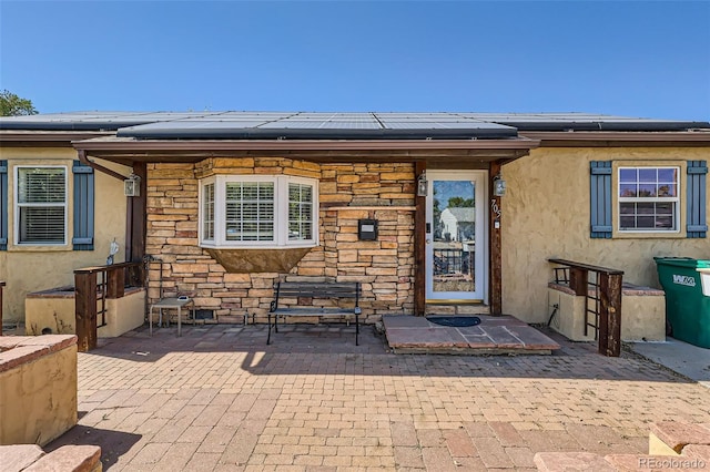 property entrance with a patio and solar panels