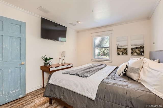 bedroom with light hardwood / wood-style flooring and crown molding