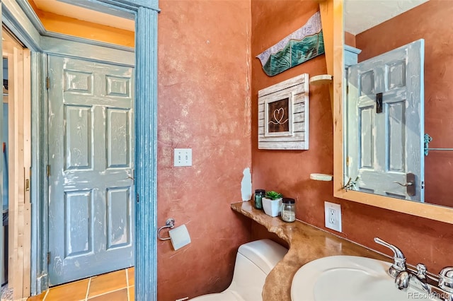 bathroom with sink, toilet, and tile patterned floors