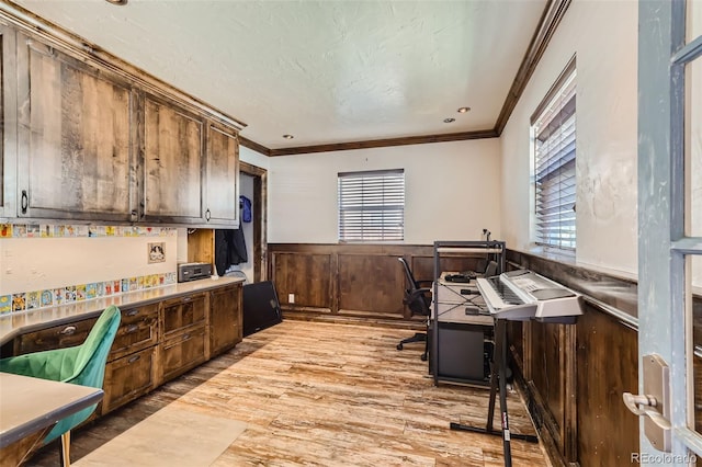 kitchen with dark brown cabinetry, ornamental molding, and light hardwood / wood-style floors