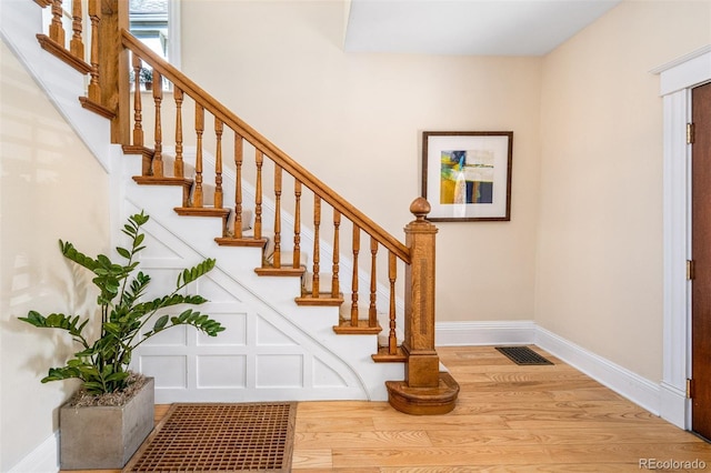 stairway featuring wood finished floors and baseboards