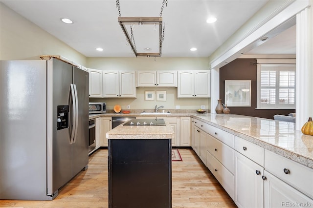 kitchen with stainless steel appliances, tile counters, a center island, light wood finished floors, and recessed lighting