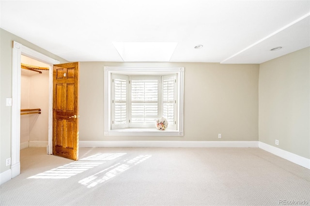 carpeted empty room featuring baseboards