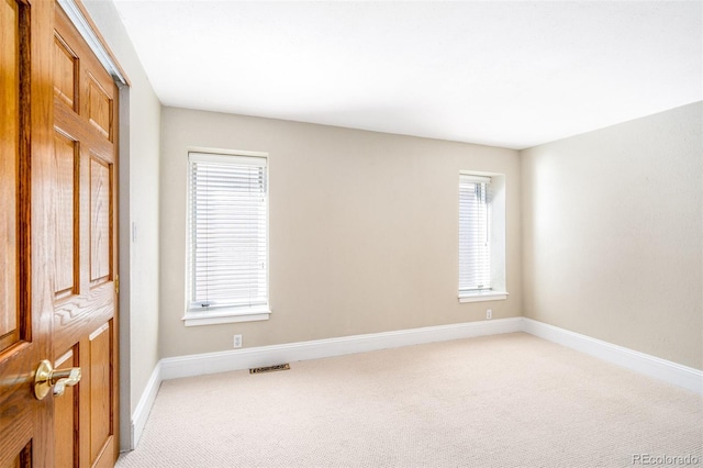 unfurnished bedroom featuring light carpet and baseboards