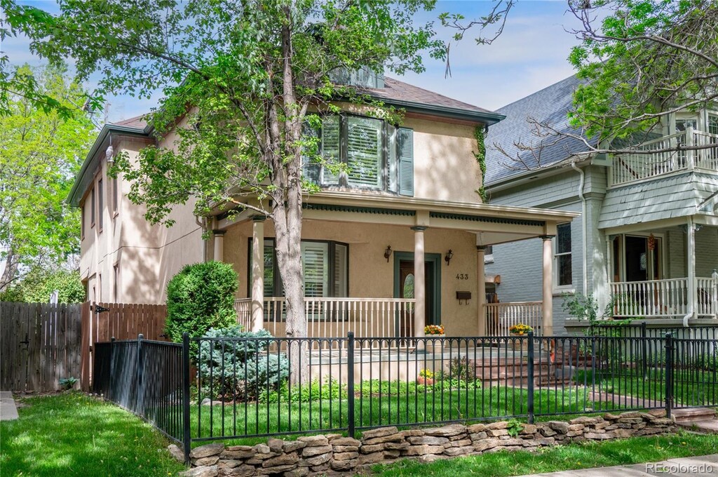 433 N Ogden St, Denver, CO 80218 - view of front of property featuring covered porch, stucco siding, and a fenced front yard