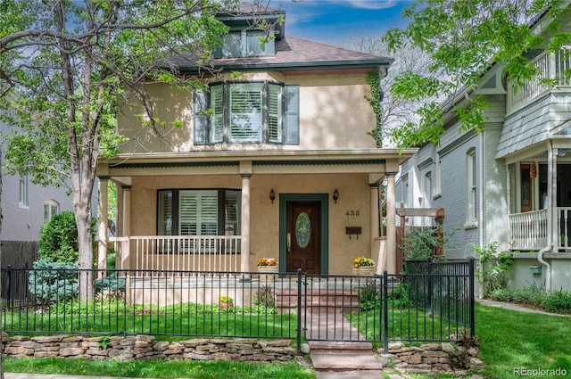 view of front of house featuring covered porch, stucco siding, and a fenced front yard