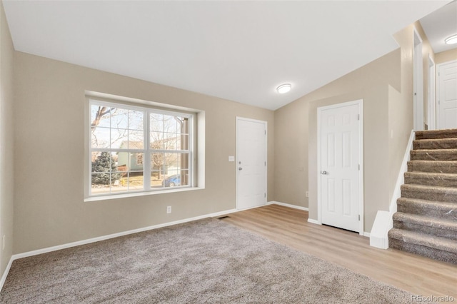 entryway with light colored carpet and vaulted ceiling