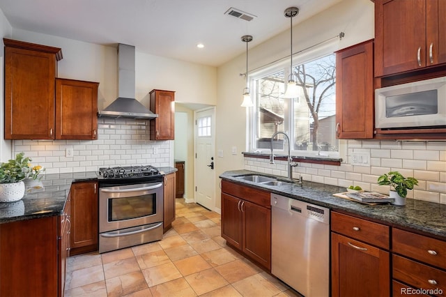 kitchen with sink, wall chimney range hood, pendant lighting, stainless steel appliances, and backsplash