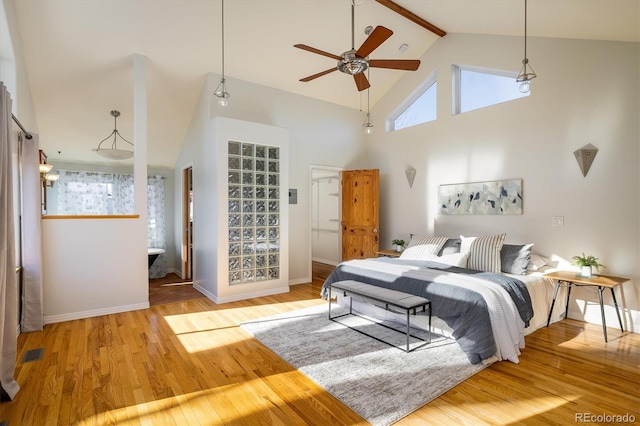 bedroom featuring wood-type flooring, high vaulted ceiling, and beamed ceiling