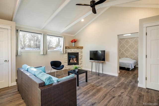 living room with ceiling fan, dark hardwood / wood-style floors, vaulted ceiling with beams, and a fireplace