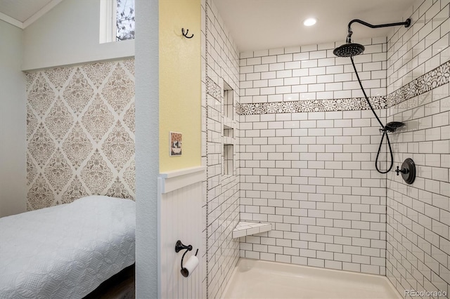 bathroom featuring ornamental molding and a tile shower