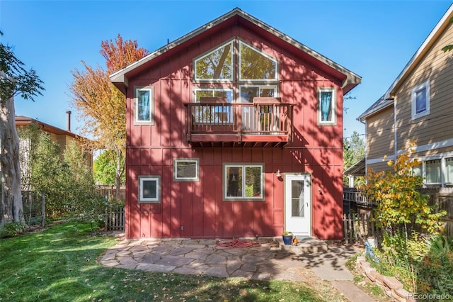 rear view of house featuring a yard, a patio area, and a balcony