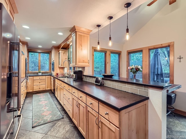845 Urban St, Lakewood, CO 80401 - kitchen featuring light brown cabinets, a peninsula, dark countertops, a sink, and stainless steel appliances