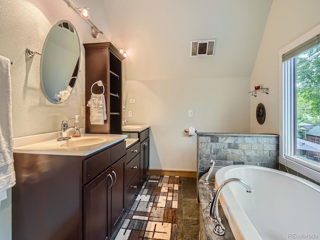 845 Urban St, Lakewood, CO 80401 - full bath with double vanity, a tub, stone tile floors, and baseboards