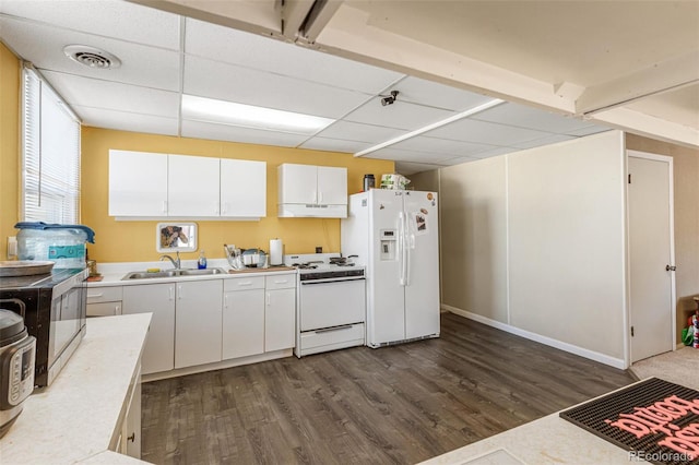 kitchen with white appliances, white cabinets, a paneled ceiling, dark wood-type flooring, and sink