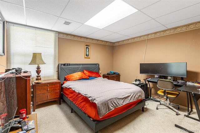 bedroom featuring a paneled ceiling and light carpet