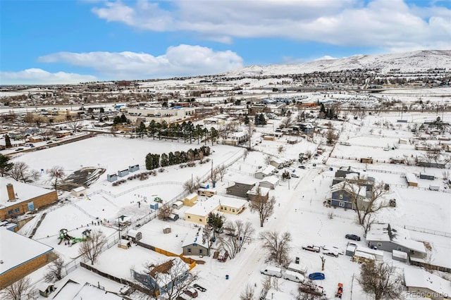 snowy aerial view featuring a residential view and a mountain view