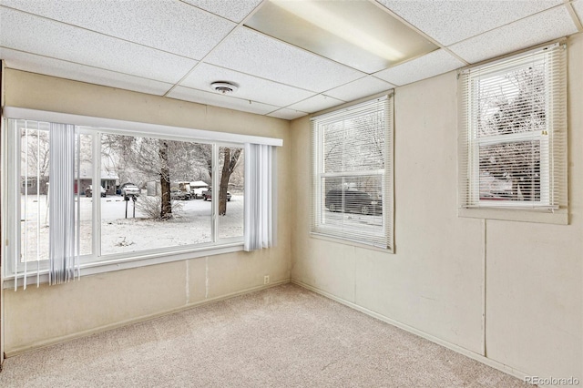 empty room featuring a paneled ceiling, baseboards, visible vents, and carpet flooring