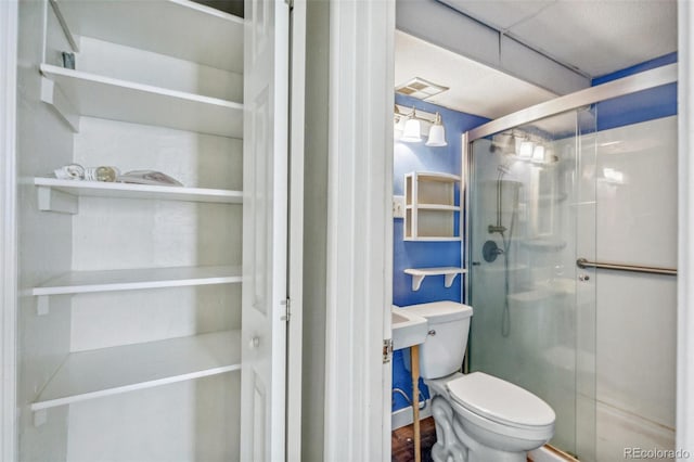 full bath with visible vents, a shower stall, and toilet