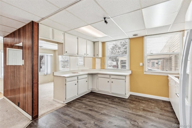 kitchen with plenty of natural light, white cabinetry, light countertops, and dark wood-type flooring