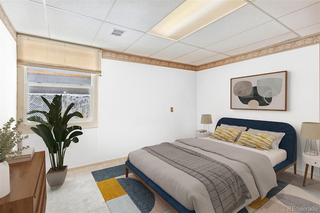 bedroom with baseboards, light colored carpet, visible vents, and a drop ceiling