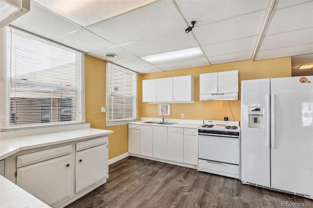 kitchen featuring white appliances, light countertops, under cabinet range hood, and white cabinetry