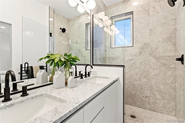 bathroom with double vanity, a sink, and tiled shower