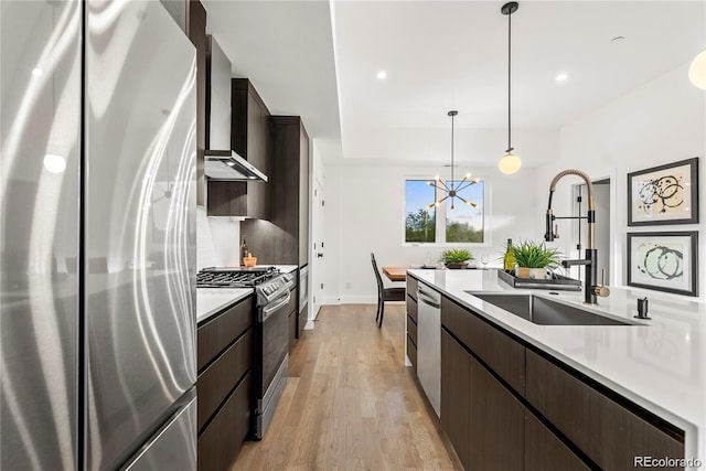 kitchen featuring stainless steel appliances, light countertops, dark brown cabinets, wall chimney exhaust hood, and tasteful backsplash