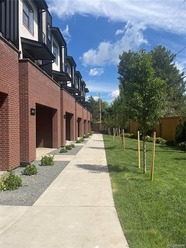 view of property's community featuring fence and a lawn