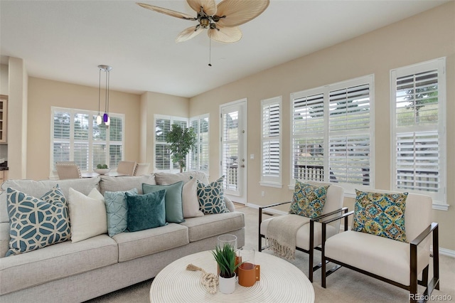 carpeted living room with ceiling fan