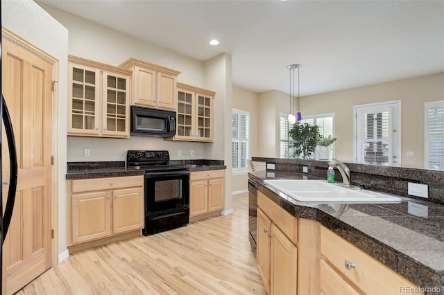 kitchen with decorative light fixtures, sink, black appliances, and light brown cabinets