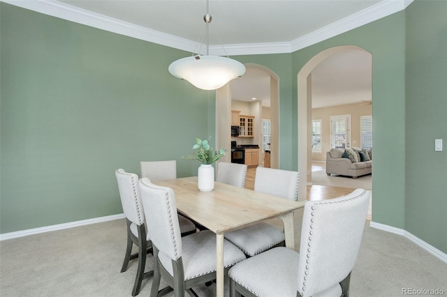 dining space featuring light carpet and crown molding