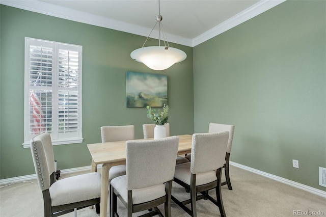 carpeted dining space with ornamental molding