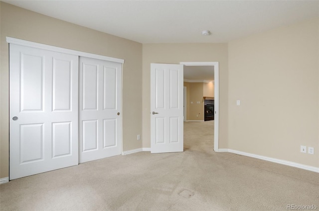 unfurnished bedroom with light carpet and a closet