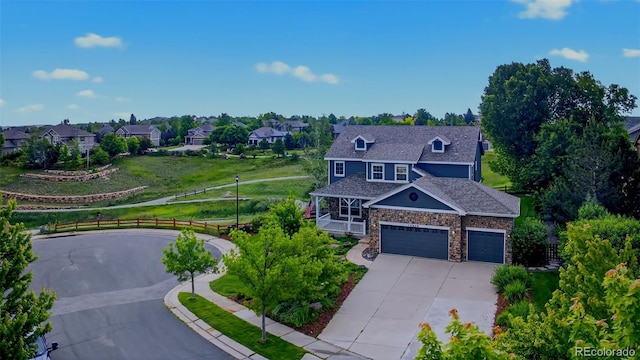 14620 Prairie Sky Ln, Broomfield, CO 80023 - view of front of house featuring concrete driveway, stone siding, a residential view, covered porch, and an attached garage