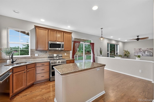 14620 Prairie Sky Ln, Broomfield, CO 80023 - kitchen featuring stainless steel appliances, light wood-style floors, backsplash, light stone counters, and recessed lighting
