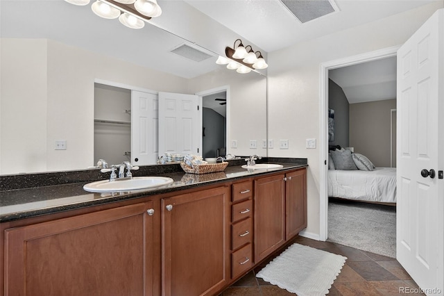 14620 Prairie Sky Ln, Broomfield, CO 80023 - ensuite bathroom featuring double vanity, stone finish floors, and a closet
