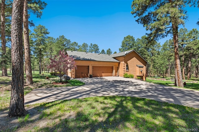 19770 Roaming Dr, Colorado Springs, CO 80908 - view of front of home featuring a garage, stucco siding, concrete driveway, and a front lawn